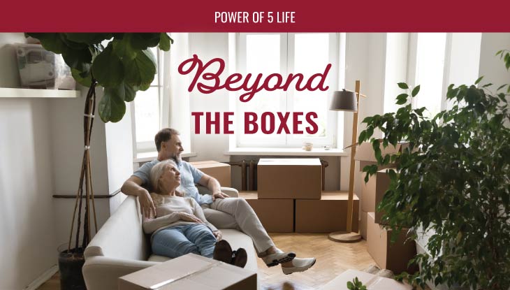 a couple sitting on the floor in the midst of moving boxes for a blog post about moving tips beyond the boxes
