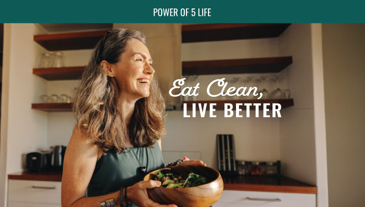 woman in the kitchen with a bowl of salad for a blog post about eat clean live better