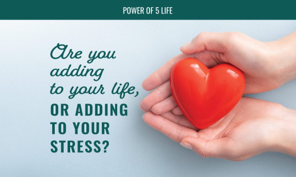 hands holding a heart-shaped stress ball in a blog post about are you adding to your life or to your stress