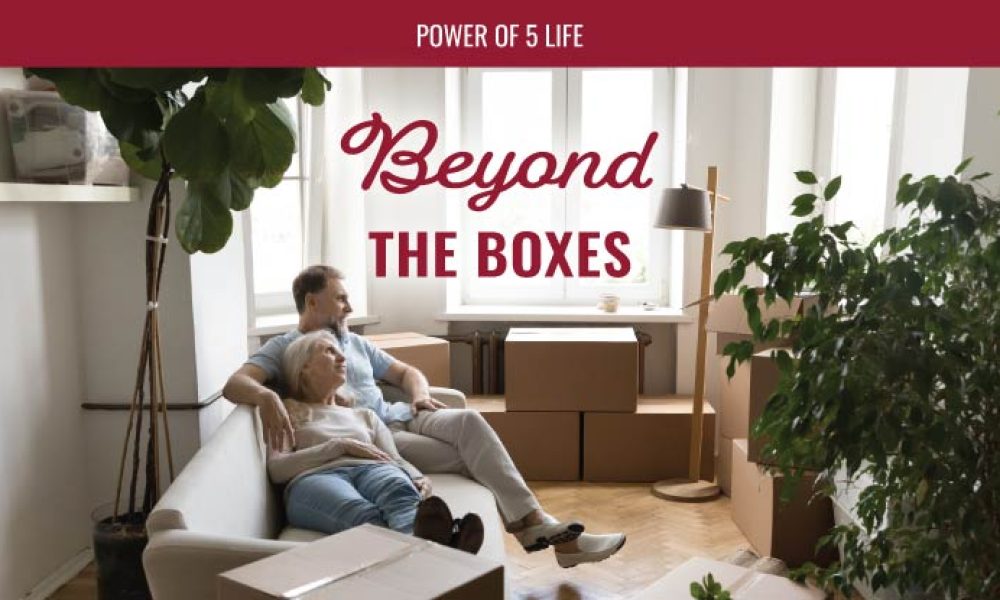 a couple sitting on the floor in the midst of moving boxes for a blog post about moving tips beyond the boxes