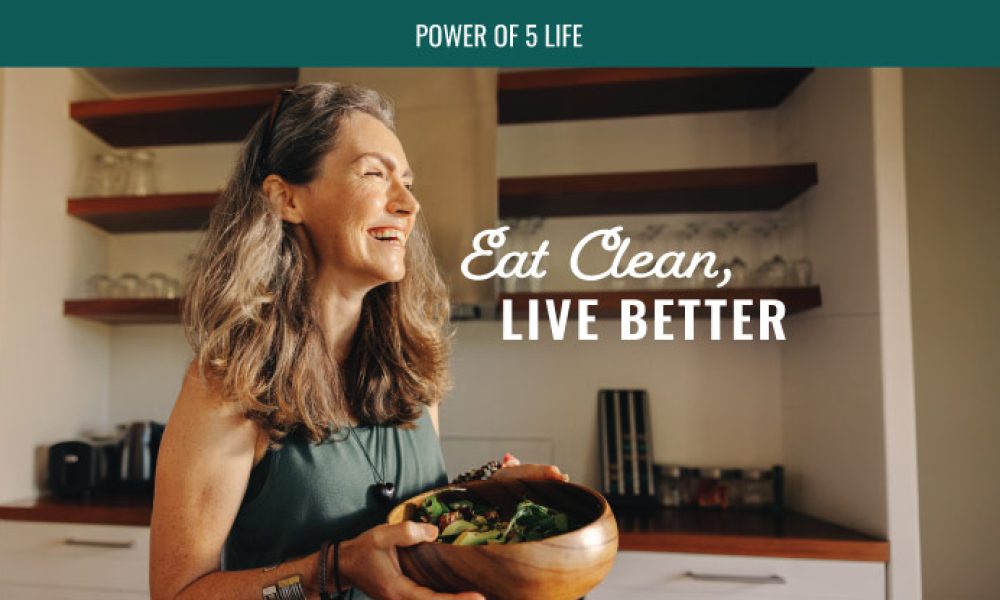 woman in the kitchen with a bowl of salad for a blog post about eat clean live better